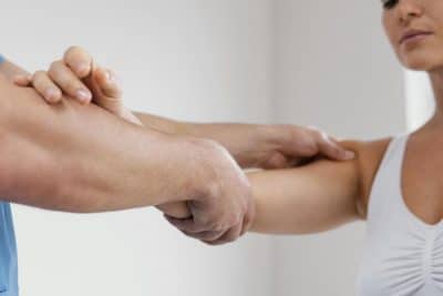 side-view-male-osteopathic-therapist-checking-female-patient-s-shoulder-joint